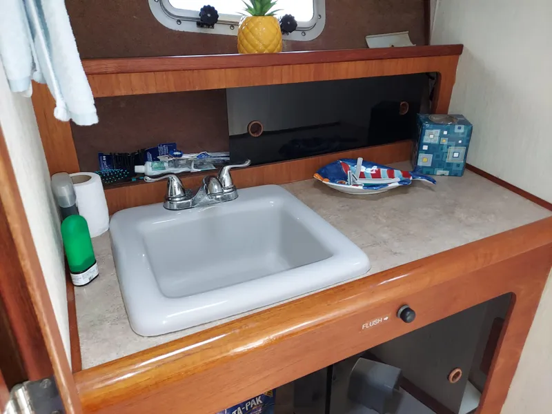 Slide: The Image of 1987 Bayliner 3870 Motoryacht bathroom sink with toiletries and decorative items. - 15