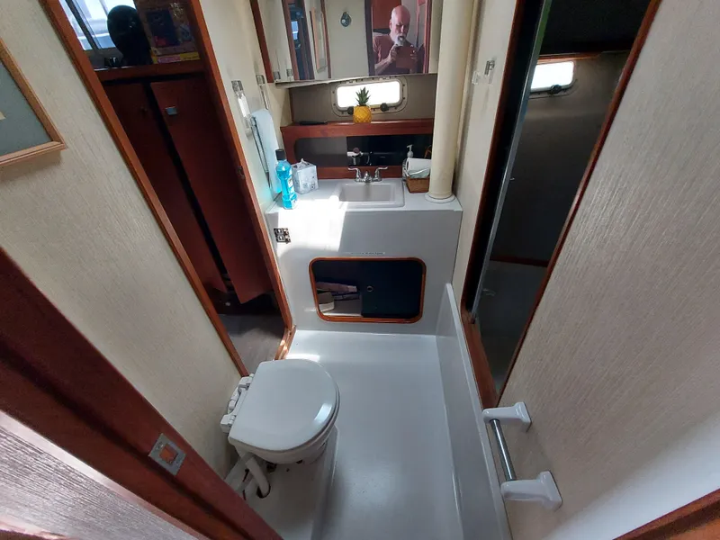 Slide: The Image of 1987 Bayliner 3870 Motoryacht bathroom with toilet, sink, mirror, and window. - 17