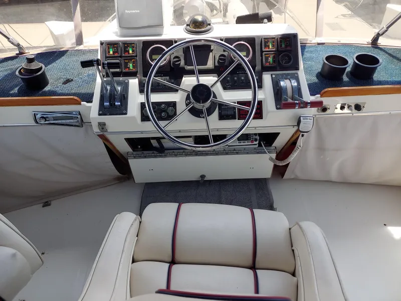 Slide: The Image of 1987 Bayliner 3870 Motoryacht helm with steering wheel, controls, and gauges. - 25