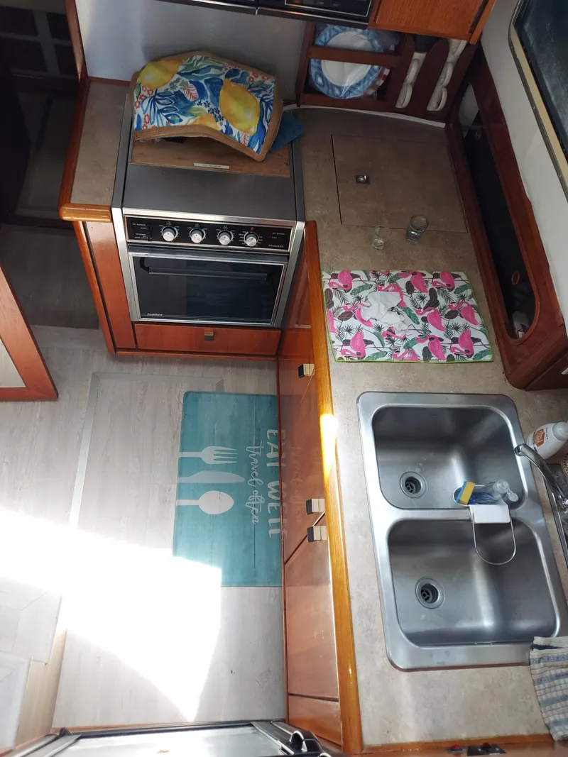 Slide: The Image of 1987 Bayliner 3870 Motoryacht kitchen with stove, double sink, and colorful decor. - 9