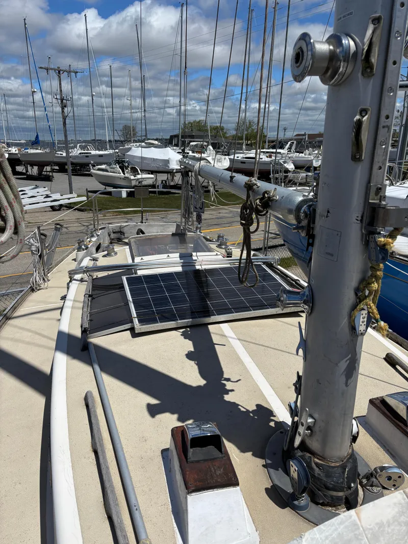 Slide: The Image of 1972 Tartan 34C sailboat deck with solar panel, docked in marina under cloudy sky. - 12