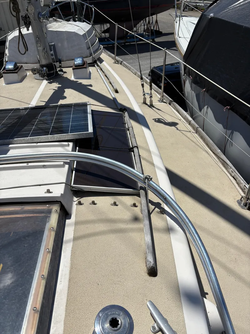 Slide: The Image of 1972 Tartan 34C sailboat deck with solar panels and railing in a marina. - 15
