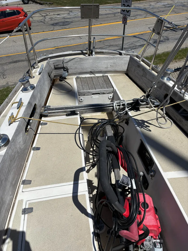 Slide: The Image of 1972 Tartan 34C sailboat deck with equipment and ropes, parked near a road. - 16