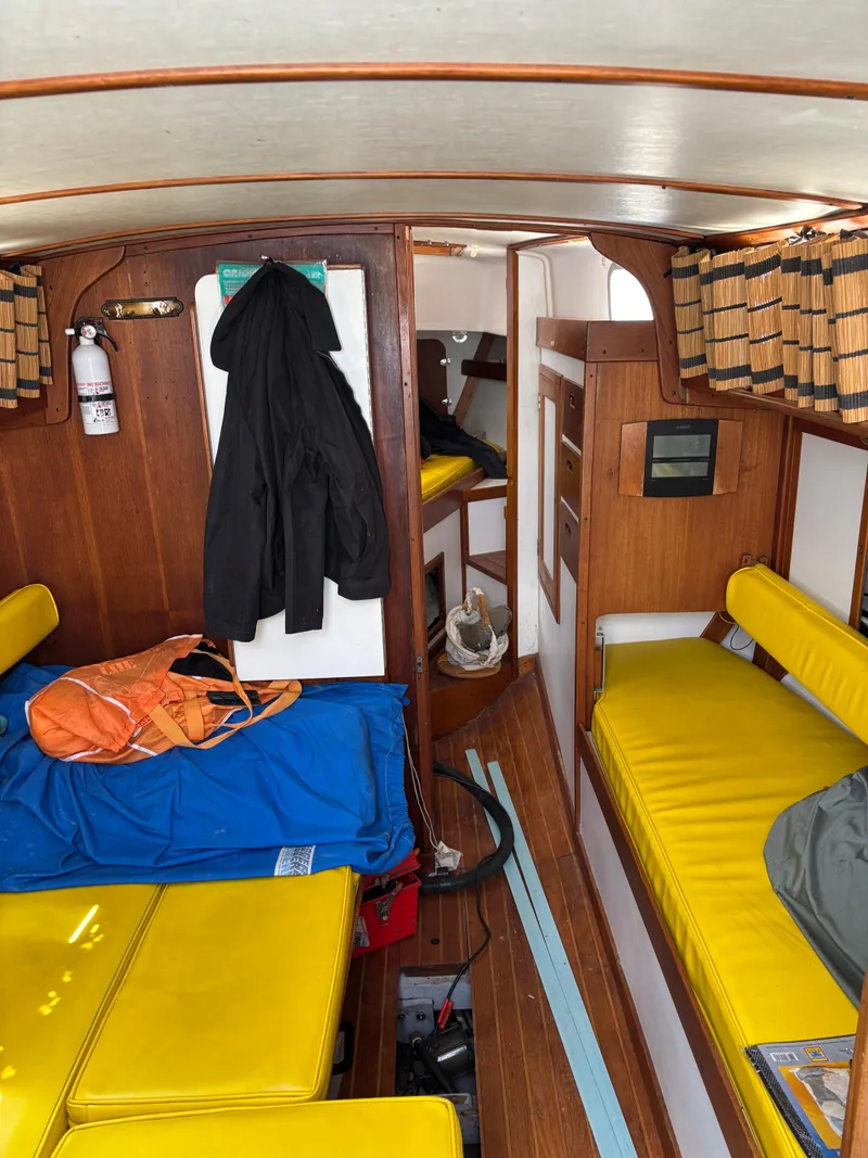Slide: The Image of Interior of a 1972 Tartan 34C sailboat with yellow cushions and wooden paneling. - 25