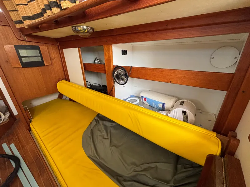 Slide: The Image of Cozy cabin interior of a 1972 Tartan 34C sailboat with yellow cushions and wooden accents. - 27