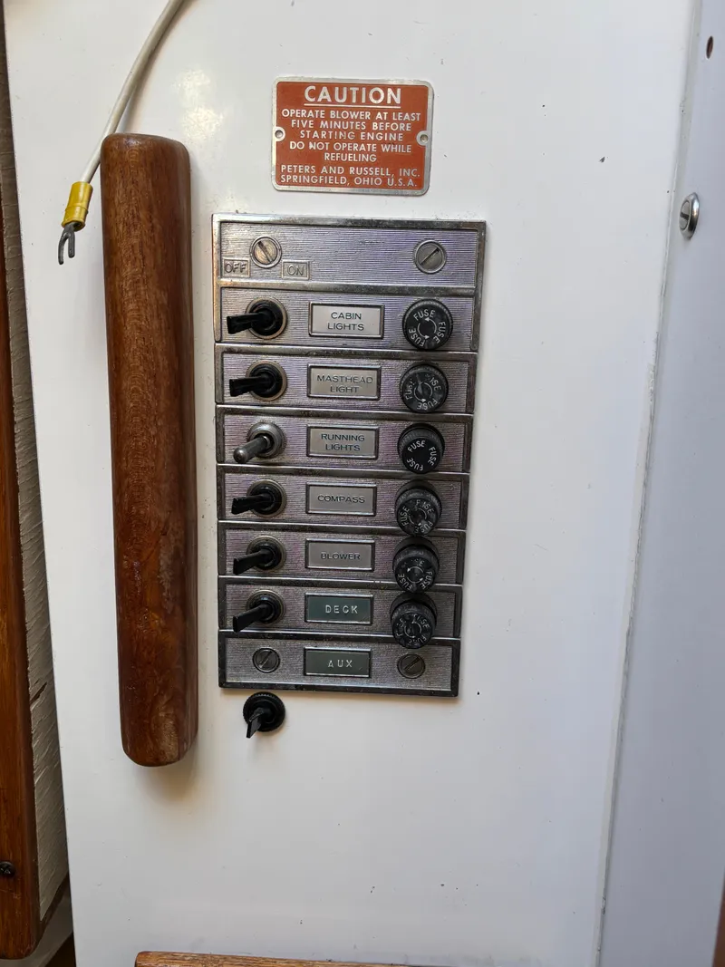 Slide: The Image of Control panel of a 1972 Tartan 34C sailboat with labeled switches and caution sign. - 29