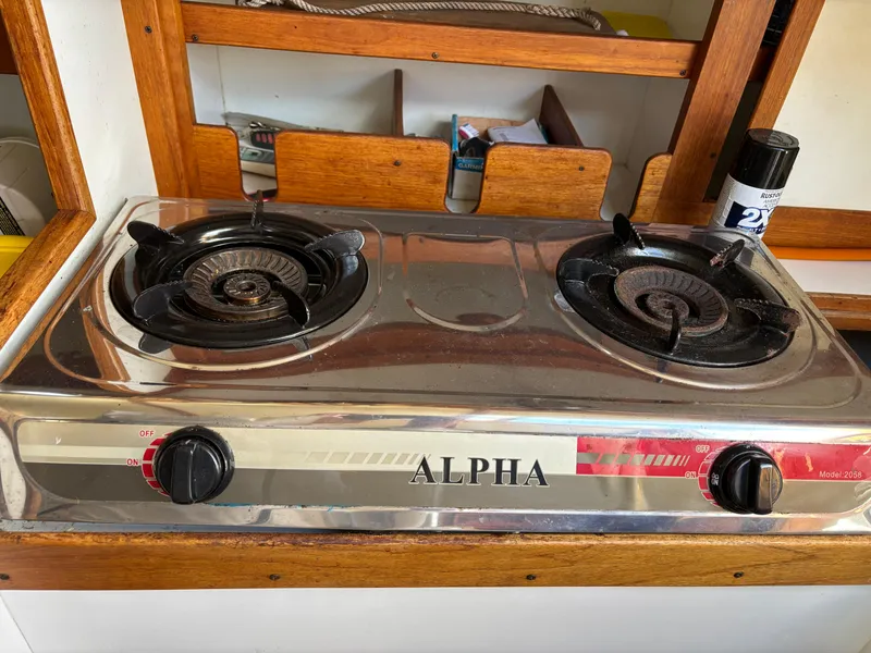 Slide: The Image of Two-burner Alpha stove on a 1972 Tartan 34C sailboat, set in a wooden kitchen area. - 33