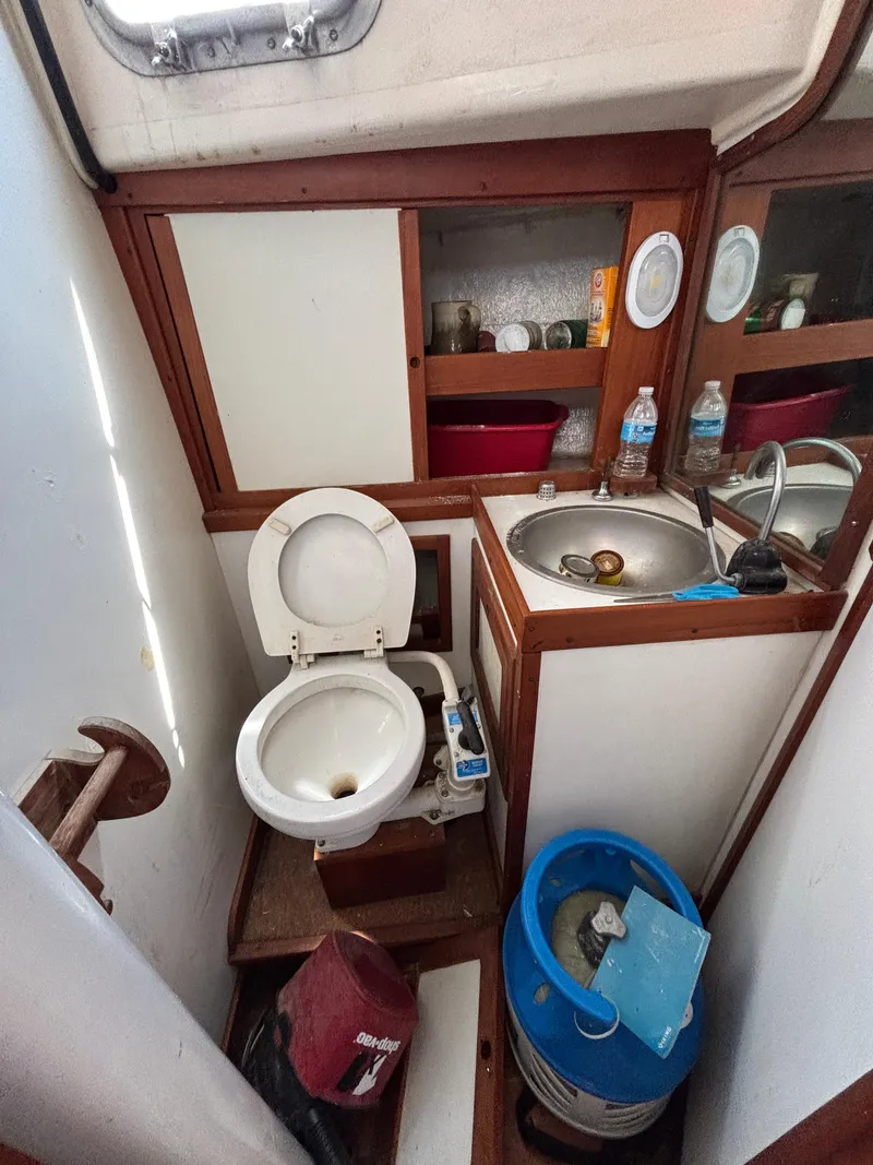 Slide: The Image of 1972 Tartan 34C boat bathroom with toilet, sink, and storage shelves. - 36