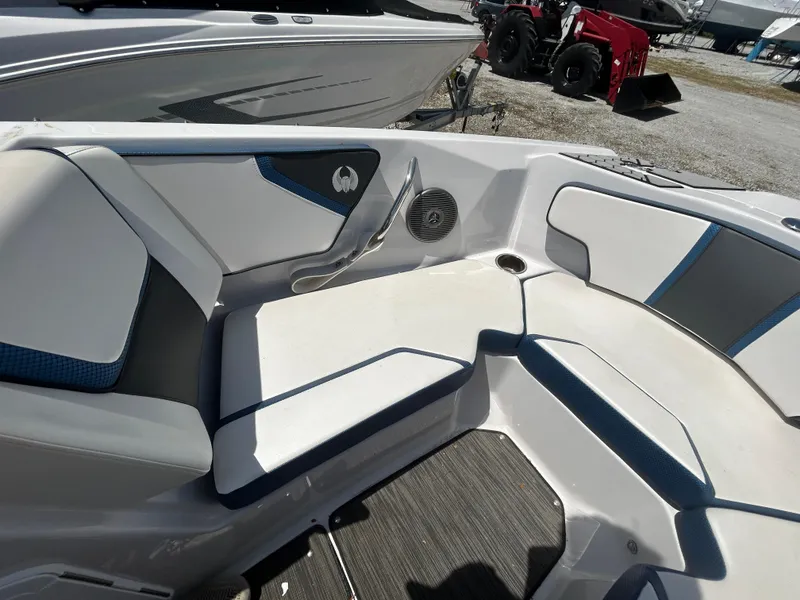 Slide: The Image of 2019 Scarab 215 ID boat interior with white and blue seating, speaker, and cup holder. - 11