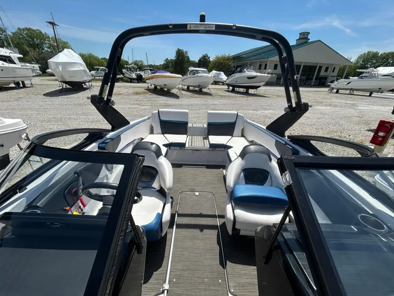 Slide: The Image of 2019 Scarab 215 ID boat interior with seating, docked in a marina. - 13