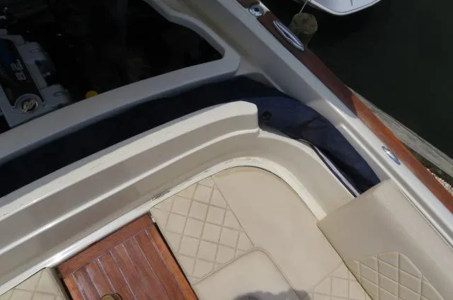 Slide: The Image of 2021 Chris-Craft Launch 27 interior with beige quilted seats and wooden accents. - 14