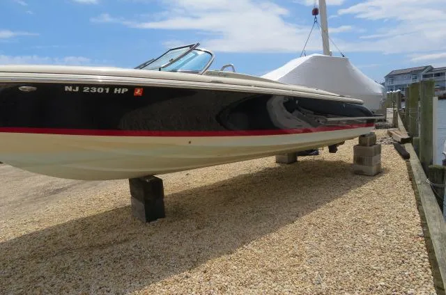 Slide: The Image of 2021 Chris-Craft Launch 27 boat on dry dock, side view, with clear sky background. - 2