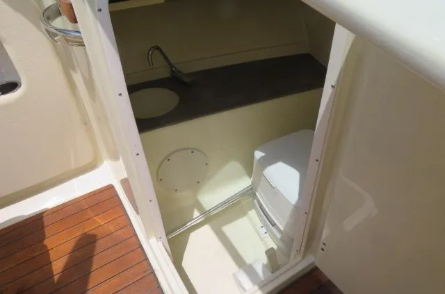 Slide: The Image of 2021 Chris-Craft Launch 27 boat interior with compact bathroom and wooden flooring. - 27