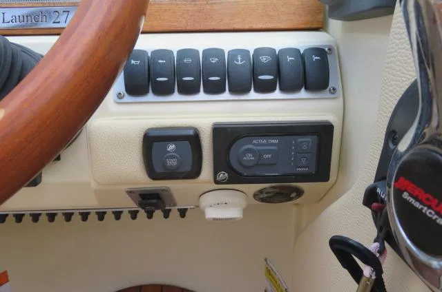 Slide: The Image of 2021 Chris-Craft Launch 27 dashboard with control panel and steering wheel. - 29