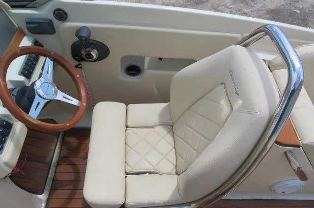 Slide: The Image of 2021 Chris-Craft Launch 27 cockpit with beige leather seat and wooden steering wheel. - 32