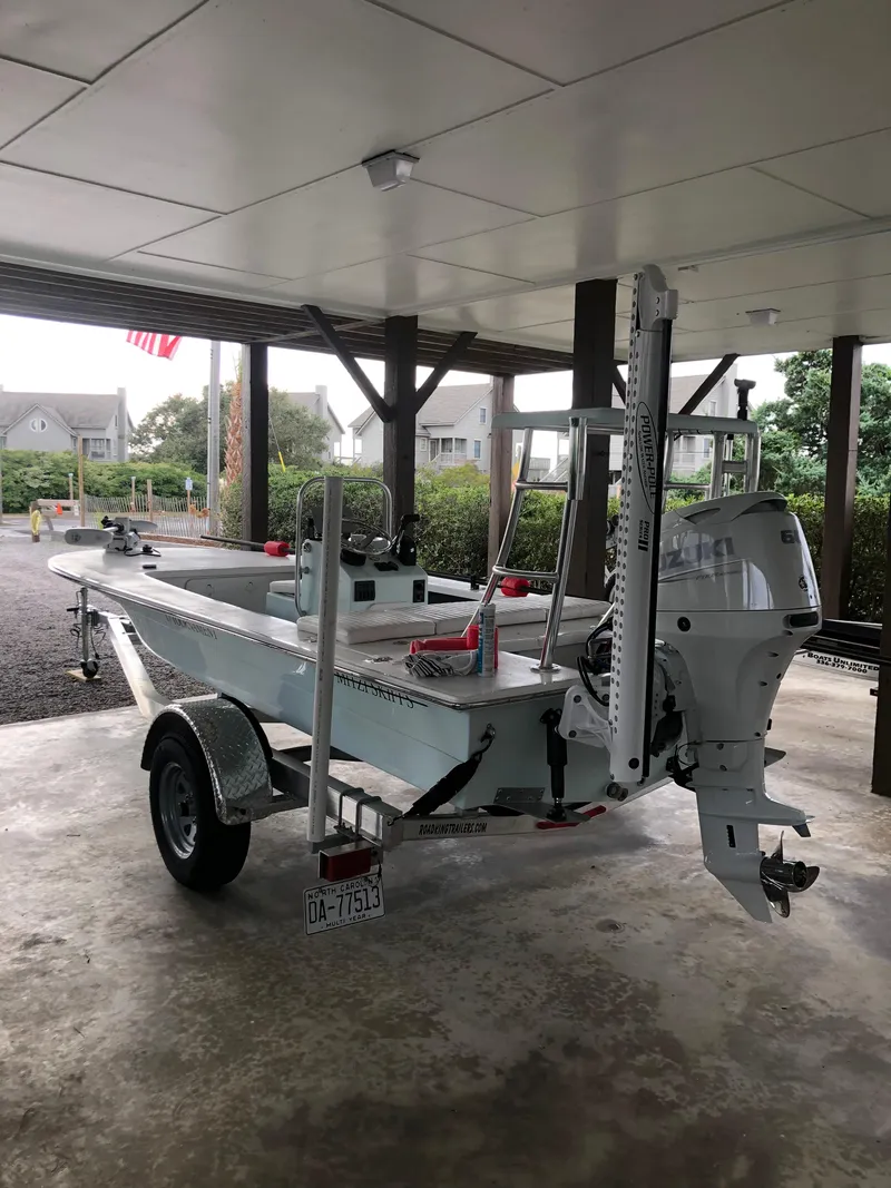 Slide: The Image of 2023 Mitzi Skiffs 17 Tournament boat on trailer under a covered area. - 2