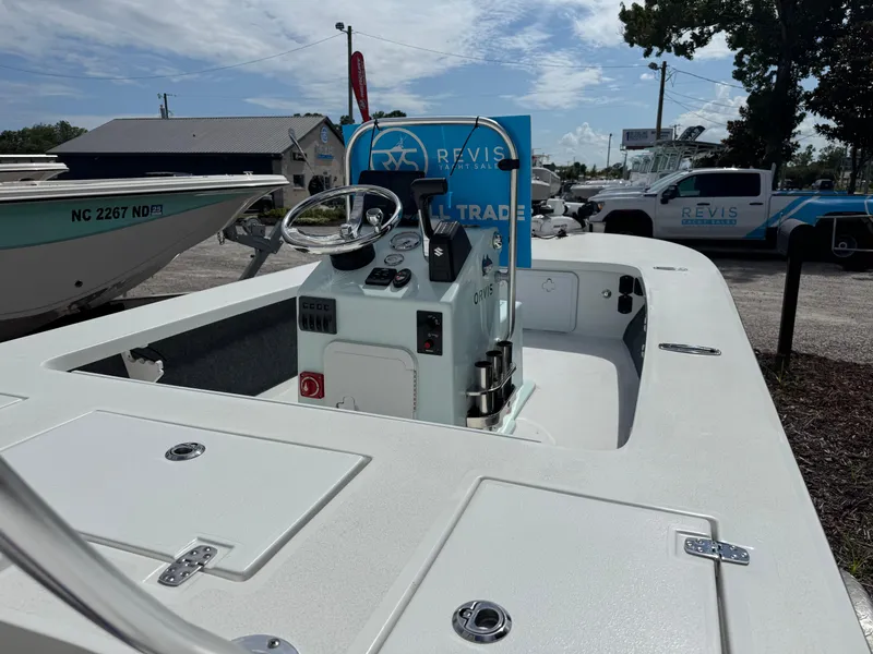 Slide: The Image of 2023 Mitzi Skiffs 17 Tournament boat at dealership, featuring steering console and storage compartments. - 6