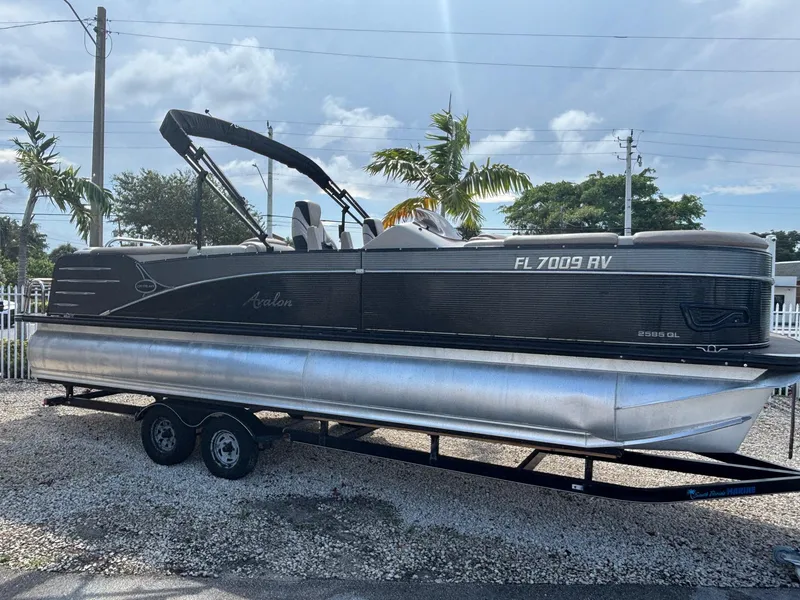 Slide: The Image of 2018 Avalon Catalina Platinum Quad Lounge boat on trailer, parked outdoors. - 1