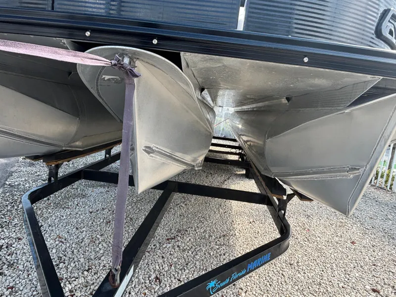 Slide: The Image of 2018 Avalon Catalina Platinum Quad Lounge pontoon boat on a trailer, showing pontoons and hull. - 7