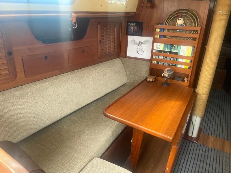 Slide: The Image of 1983 Sabre 38 Mk I Swing Keel interior with wooden table and cushioned seating. - 11