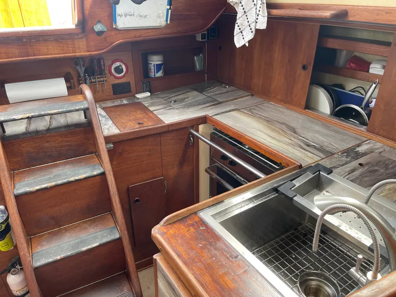 Slide: The Image of 1983 Sabre 38 Mk I Swing Keel yacht interior with wooden cabinetry and compact kitchen. - 14