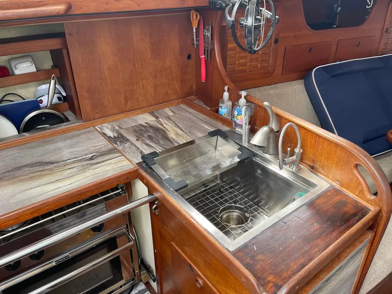 Slide: The Image of Interior of 1983 Sabre 38 Mk I sailboat galley with sink and wooden cabinetry. - 15