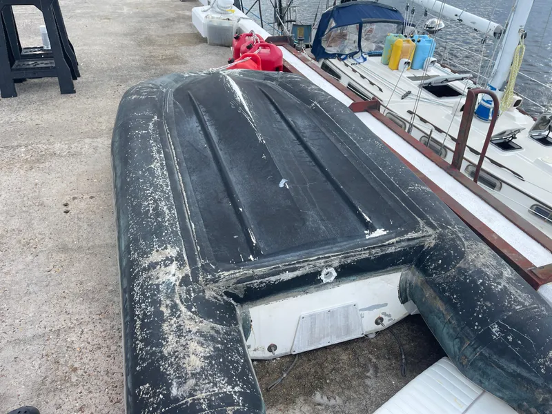 Slide: The Image of Weathered inflatable boat on dock beside Sabre Mk I Swing Keel, 1983 model. - 20