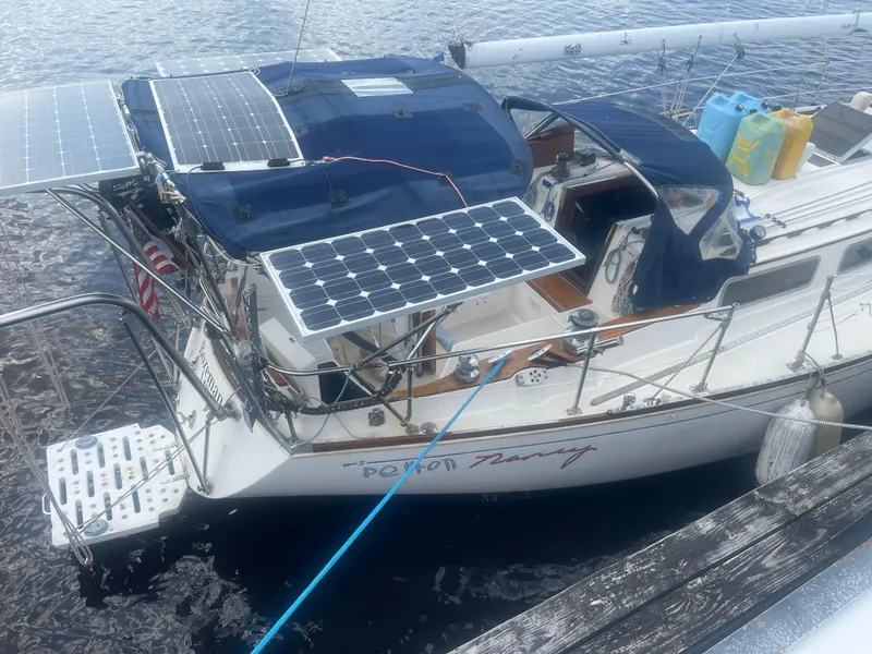 Slide: The Image of 1983 Sabre Mk I Swing Keel sailboat with solar panels docked on water. - 3