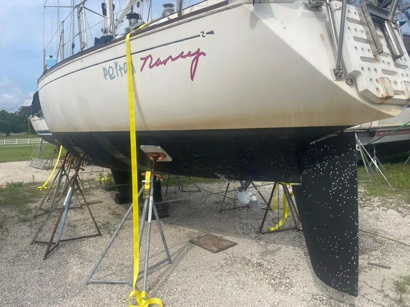 Slide: The Image of 1983 Sabre 38 Mk I Swing Keel sailboat on stands, undergoing maintenance. - 4