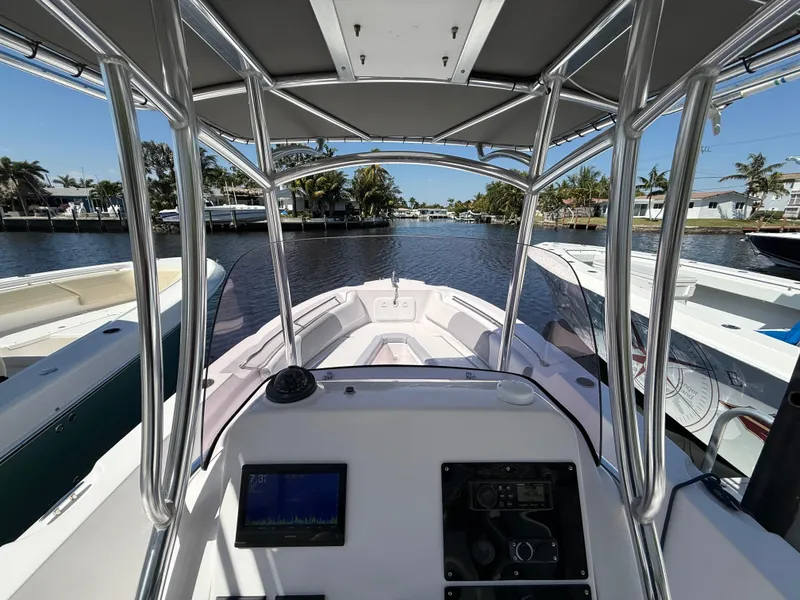 Slide: The Image of 2019 Pro-Line 23 Sport boat interior with console, docked by a scenic waterfront. - 20