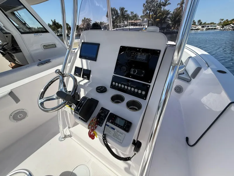 Slide: The Image of 2019 Pro-Line 23 Sport boat console with steering wheel and navigation equipment. - 22