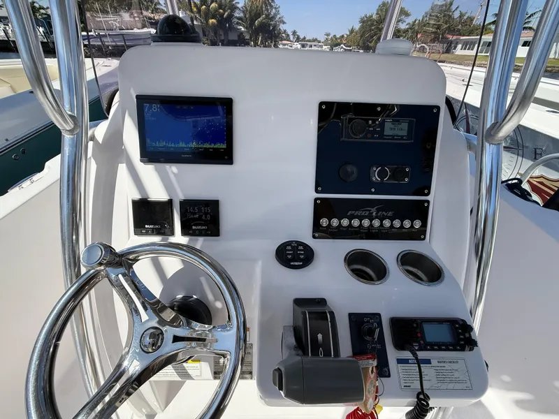 Slide: The Image of 2019 Pro-Line 23 Sport boat dashboard with steering wheel and electronic controls. - 24