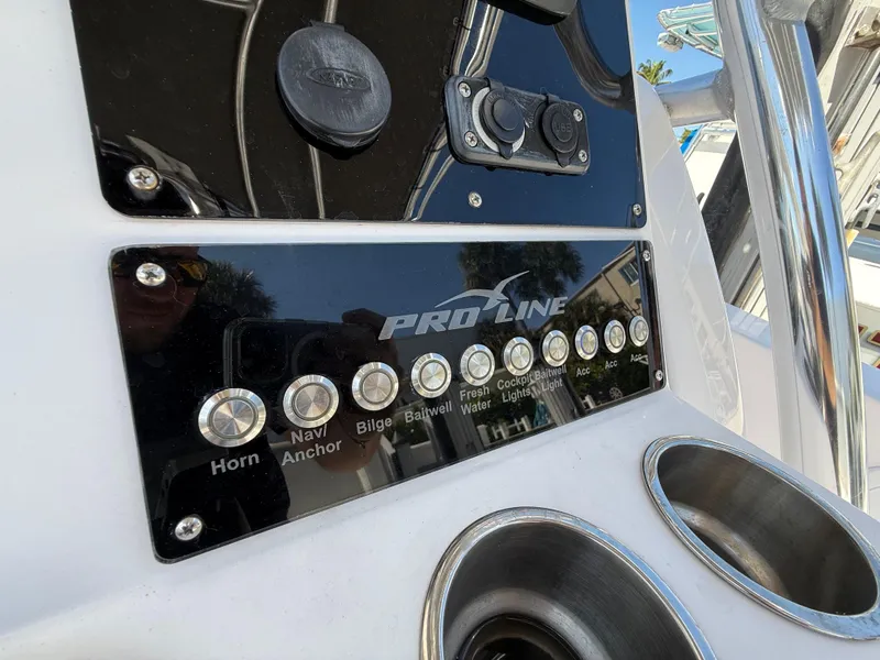 Slide: The Image of Control panel of 2019 Pro-Line 23 Sport boat with labeled buttons and cup holders. - 26