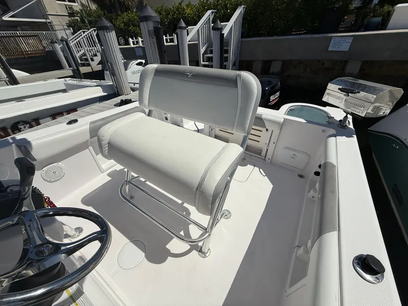 Slide: The Image of 2019 Pro-Line 23 Sport boat interior with white seating and steering wheel. - 29
