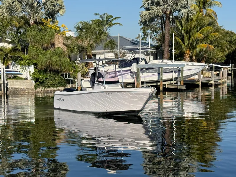 Slide: The Image of 2019 Pro-Line 23 Sport boat docked in a scenic waterfront setting. - 6