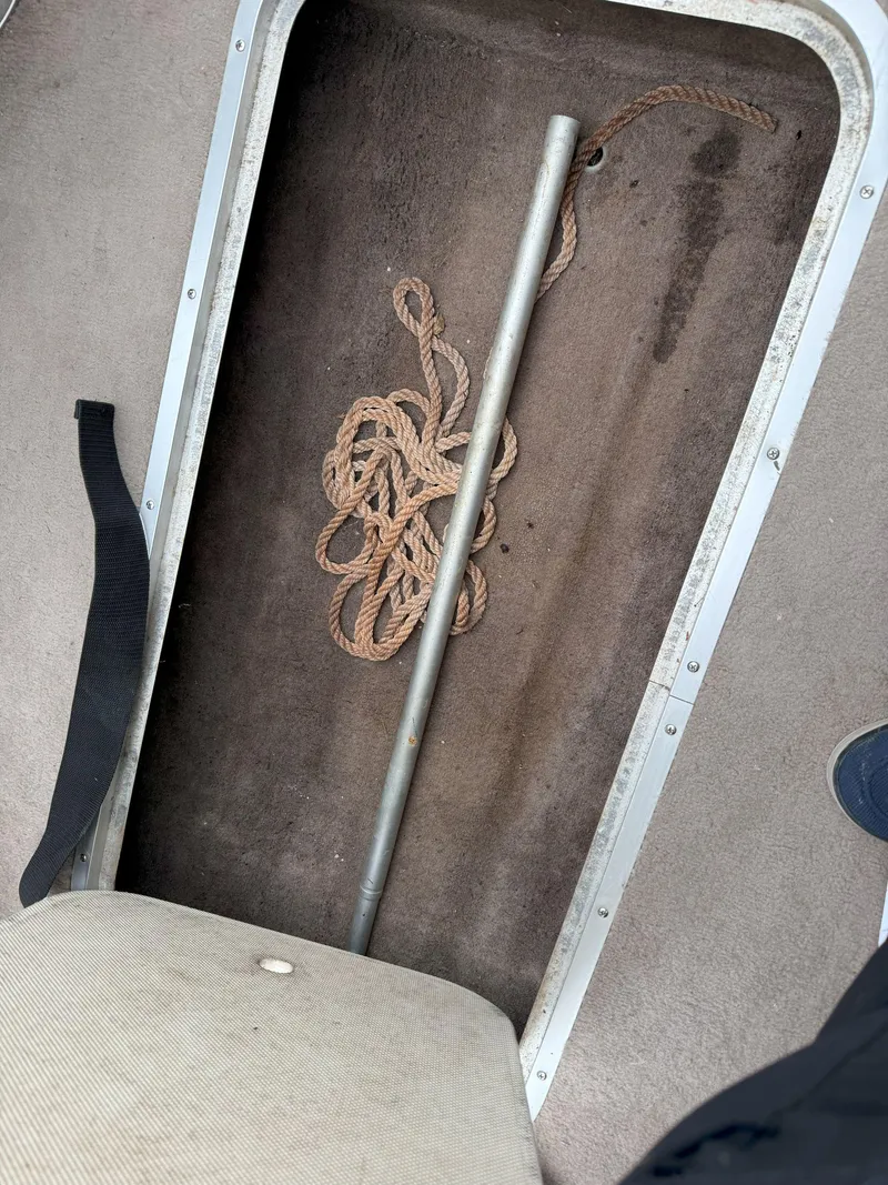 Slide: The Image of Storage compartment in a 2003 Stingray 200LX boat with rope and metal pole. - 13