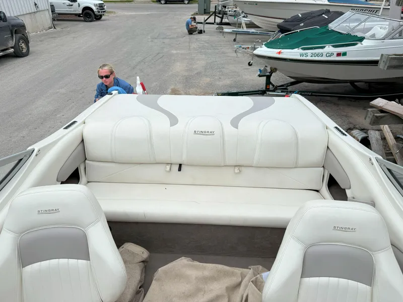Slide: The Image of 2003 Stingray 200LX boat with white interior, parked on a lot with other boats. - 14