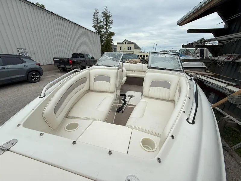 Slide: The Image of 2003 Stingray 200LX boat with white interior, parked outdoors near buildings and vehicles. - 15