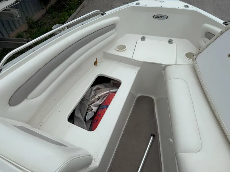 Slide: The Image of 2003 Stingray 200LX boat interior with white seating and storage compartment. - 19