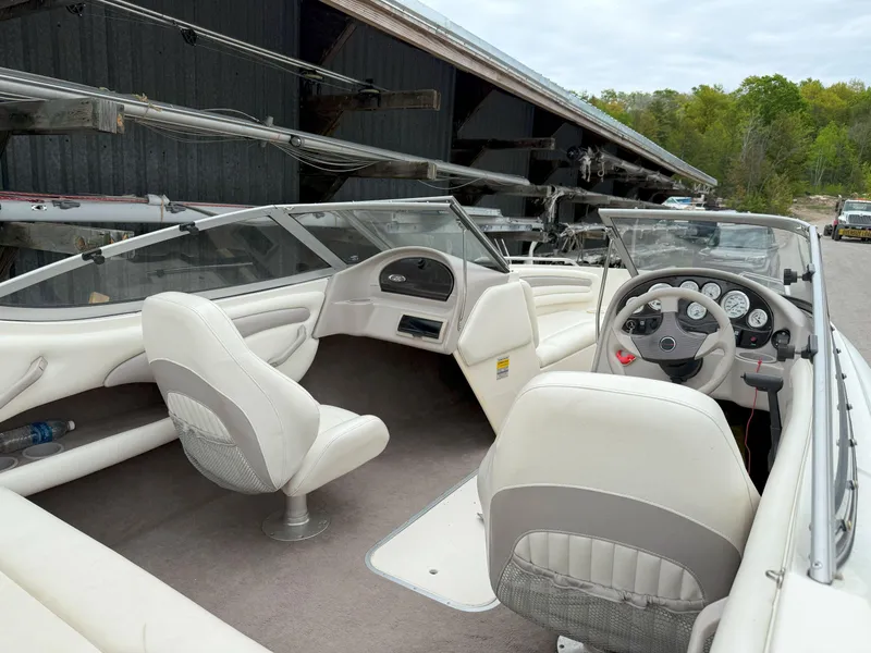 Slide: The Image of 2003 Stingray 200LX boat interior with white seating and dashboard controls. - 7