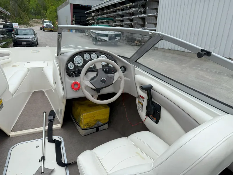 Slide: The Image of 2003 Stingray 200LX boat interior with white seating and dashboard controls. - 8