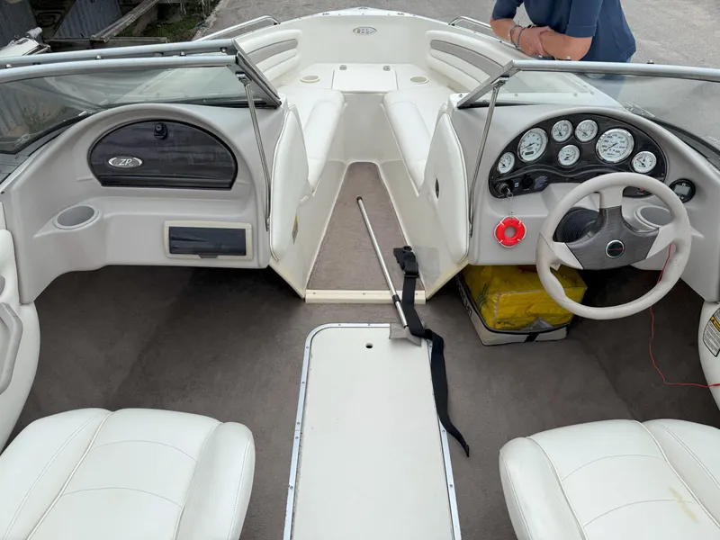 Slide: The Image of 2003 Stingray 200LX boat interior with white seating and dashboard controls. - 9