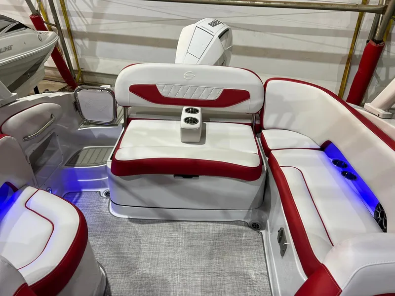 Slide: The Image of 2024 Crownline 250XSS boat interior with red and white seating, cup holders, and blue accent lighting. - 4