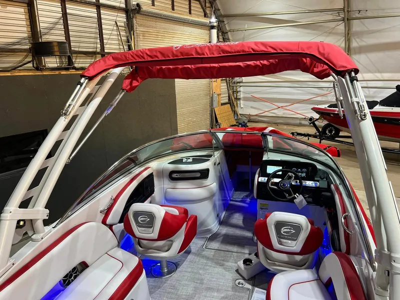 Slide: The Image of 2024 Crownline 250XSS boat interior with red and white seating, illuminated dashboard, and canopy. - 9