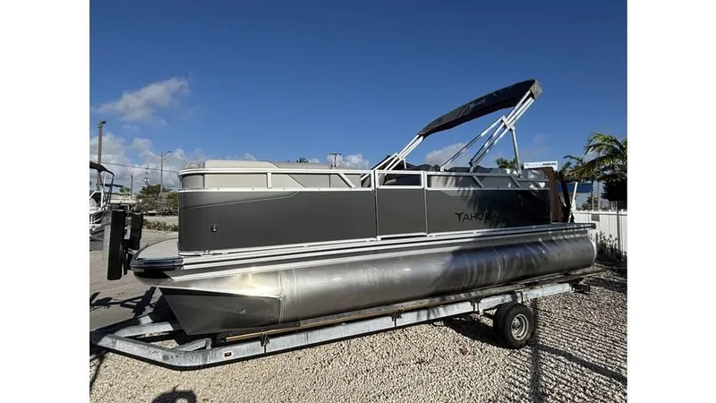 Slide: The Image of 2025 Tahoe Pontoon 19 Quad Lounge Sport on trailer, parked outdoors. - 1