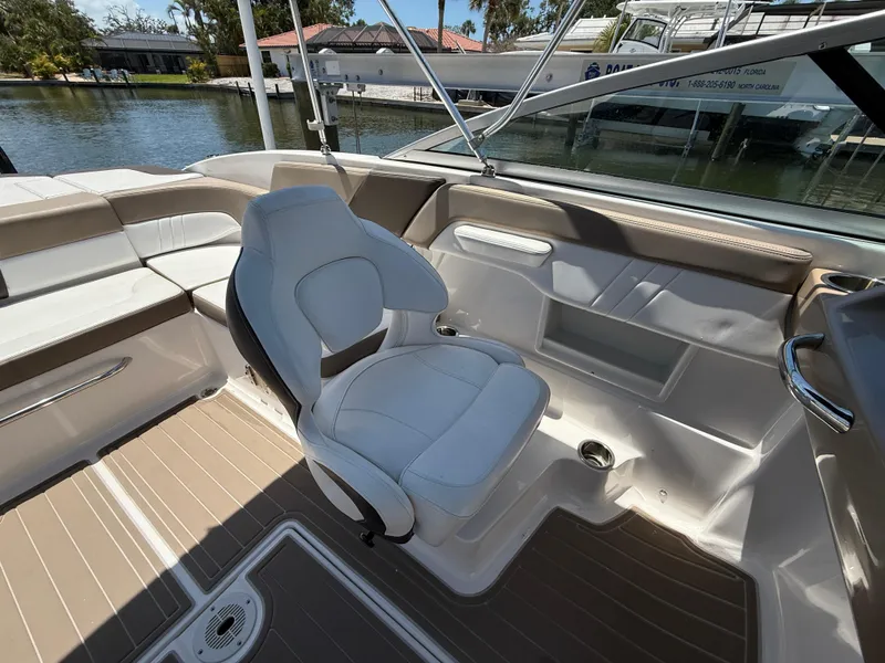 Slide: The Image of 2021 Chaparral 23 SSi OB boat interior with white seating and wood flooring. - 13