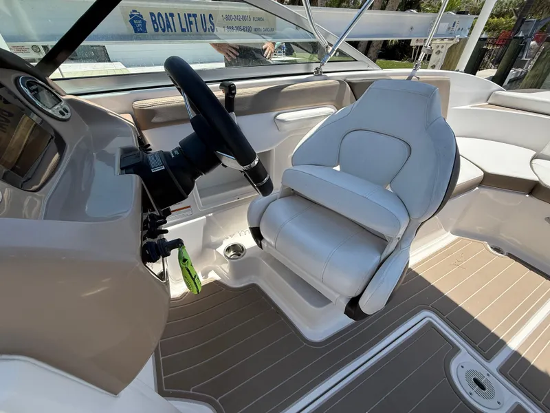 Slide: The Image of 2021 Chaparral 23 SSi OB boat interior with steering wheel and white captain's seat. - 14