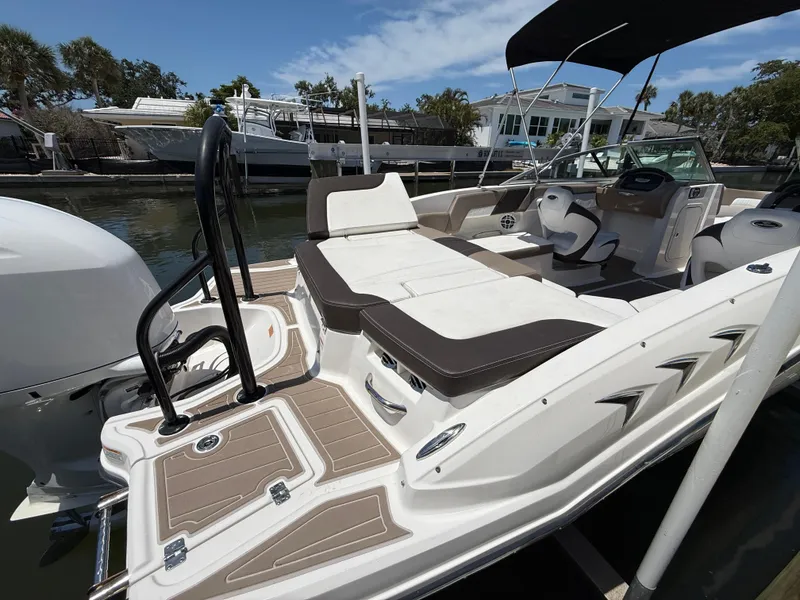 Slide: The Image of 2021 Chaparral 23 SSi OB boat with spacious seating and sleek design at a dock. - 19