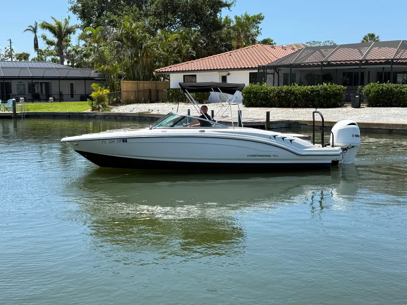 Slide: The Image of 2021 Chaparral 23 SSi OB boat on calm water near waterfront homes. - 4