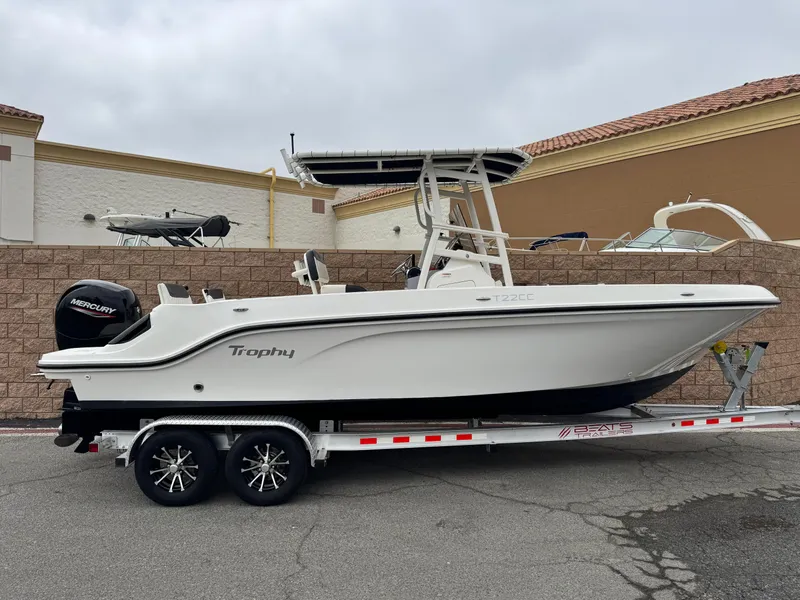 The Image of 2022 Bayliner Trophy T22CC boat on trailer, parked outdoors. - 0